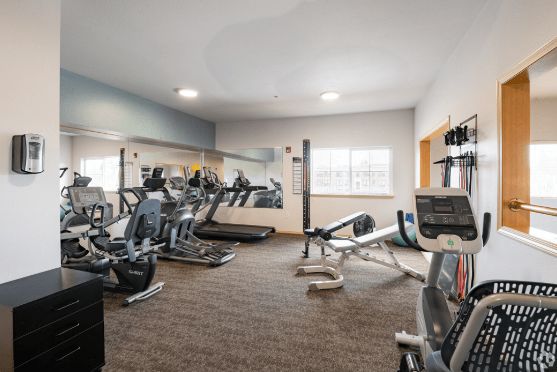 A well-equipped gym with various fitness machines and weights.