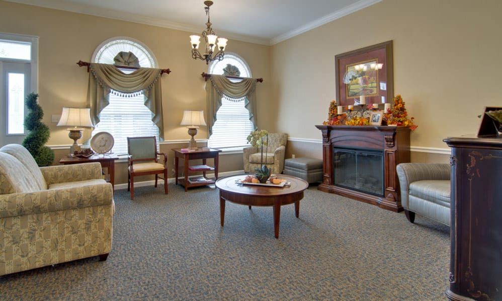 A traditional living room featuring elegant furniture, a decorative fireplace, and classic drapes.