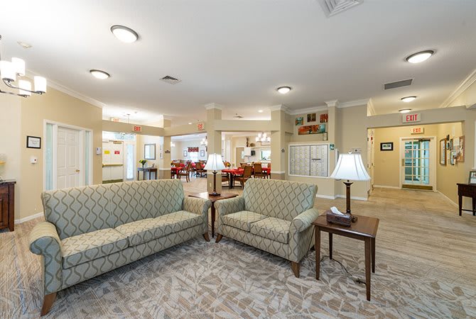 A cozy living room with sofas, lamps, and warm decor.