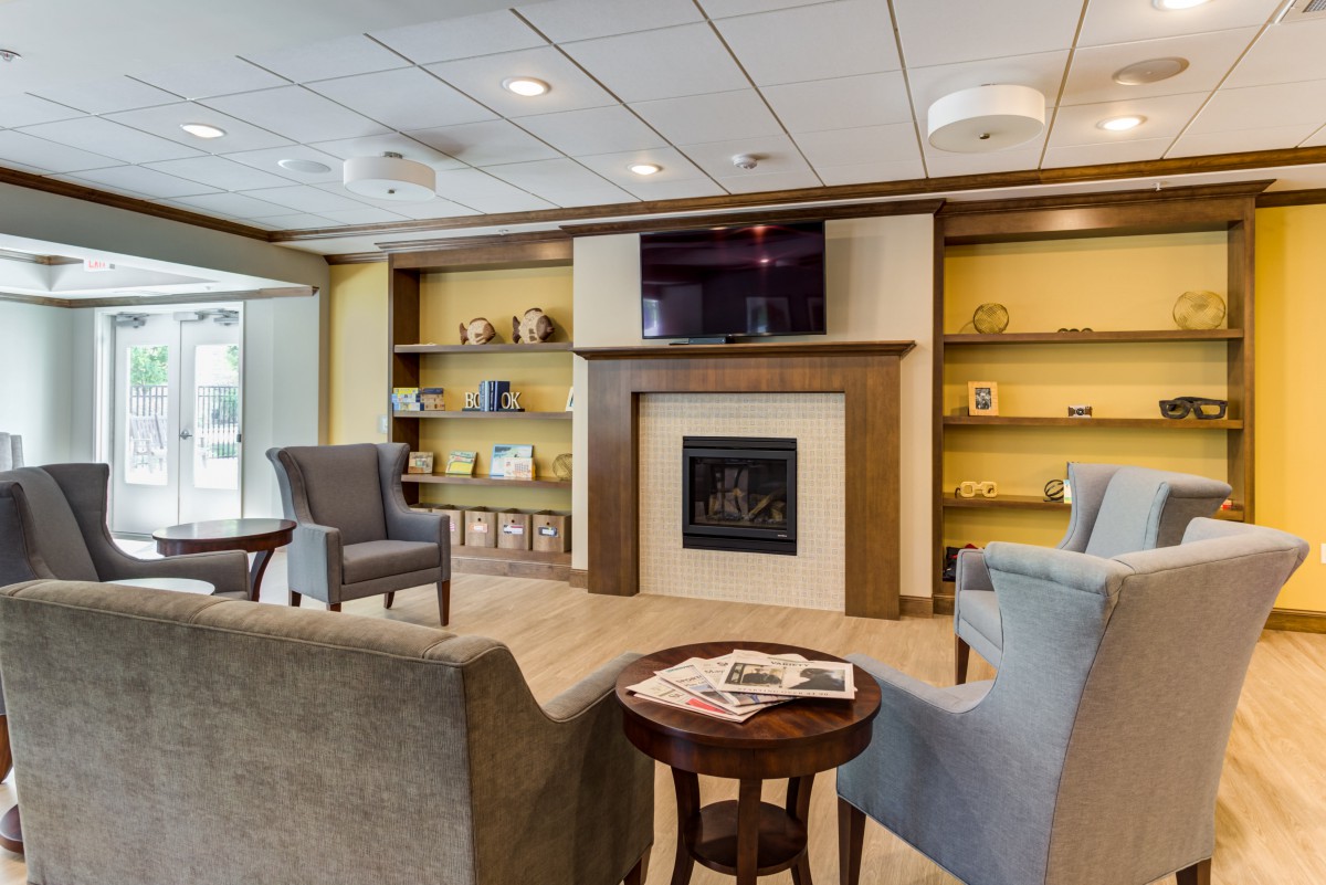 A cozy living room with a fireplace, ample seating, and built-in bookshelves.