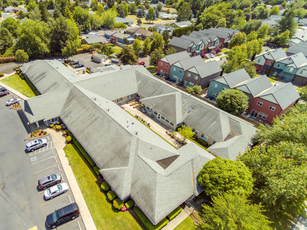 Aerial view of a large building surrounded by a neighborhood and greenery.