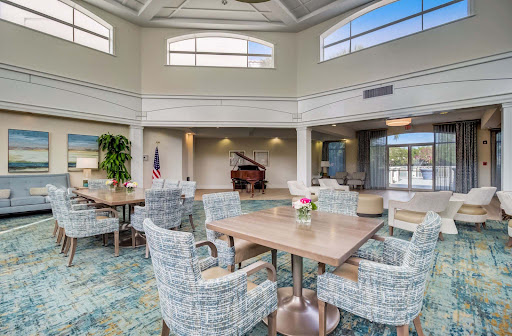 A spacious and inviting lounge area featuring a piano, comfortable seating, and abundant natural light.
