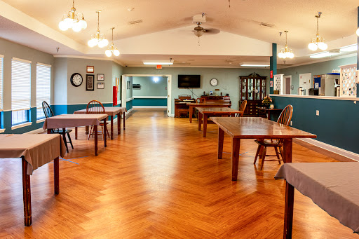 A spacious community room featuring wooden tables and a warm ambiance.