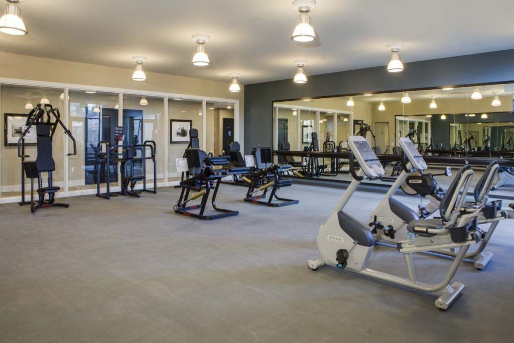 A spacious gym with various exercise equipment including cardio machines.