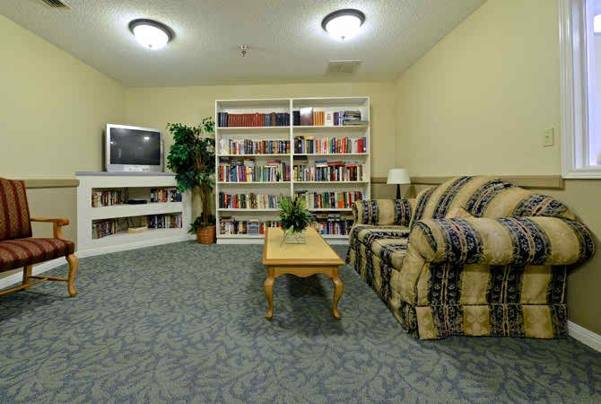 A cozy living room with a bookshelf, sofa, television, and coffee table.