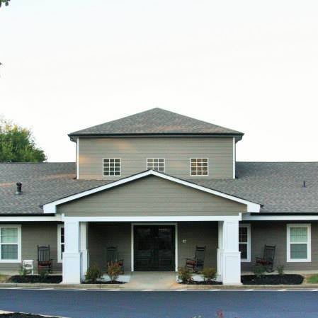 A view of a residential building entrance with a gabled roof and symmetrical design.