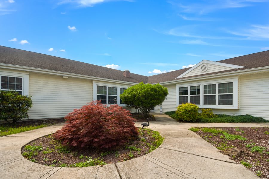 A suburban house with landscaped front yard under a clear blue sky.