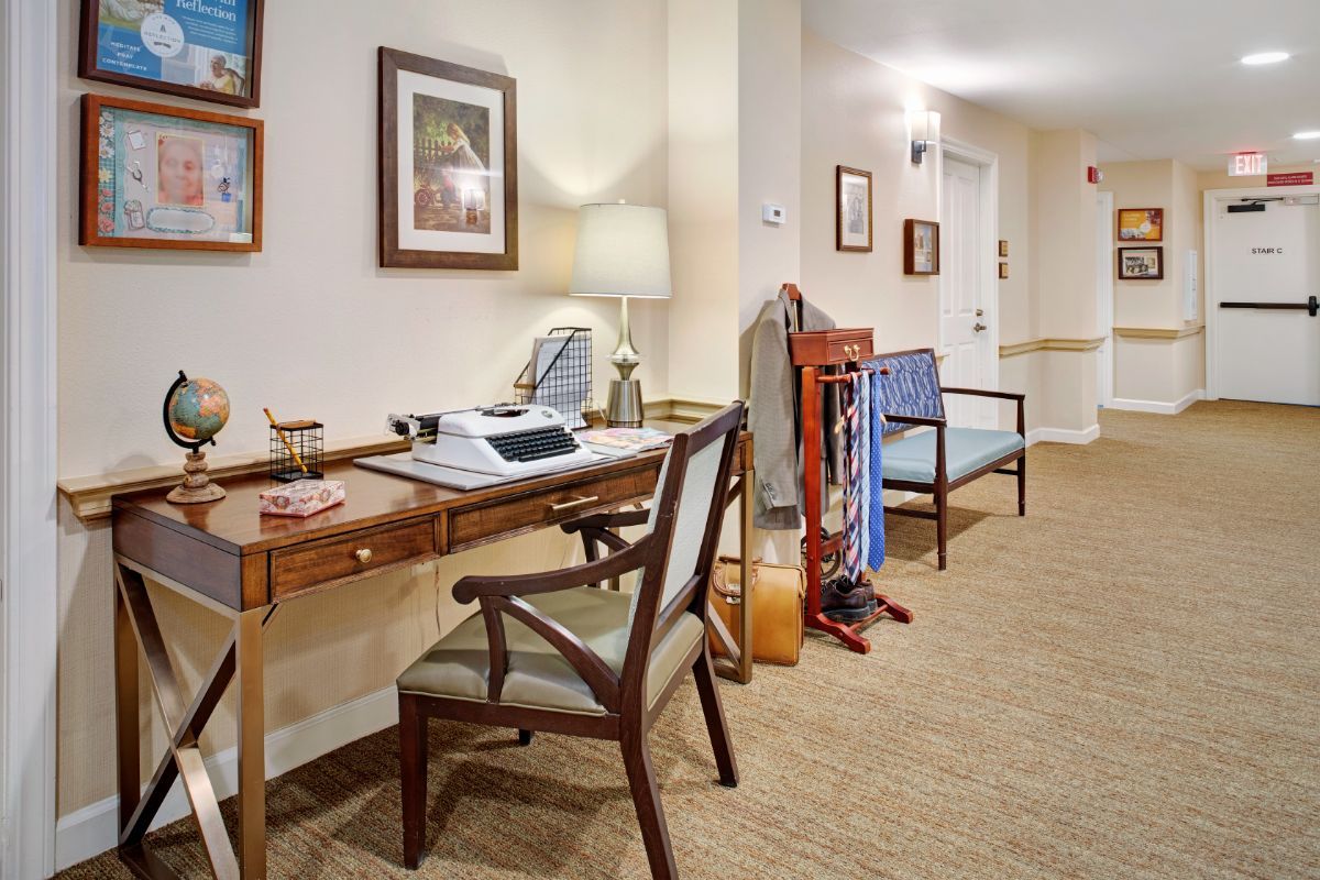 A well-organized office space with a desk and chairs in a hallway setting.