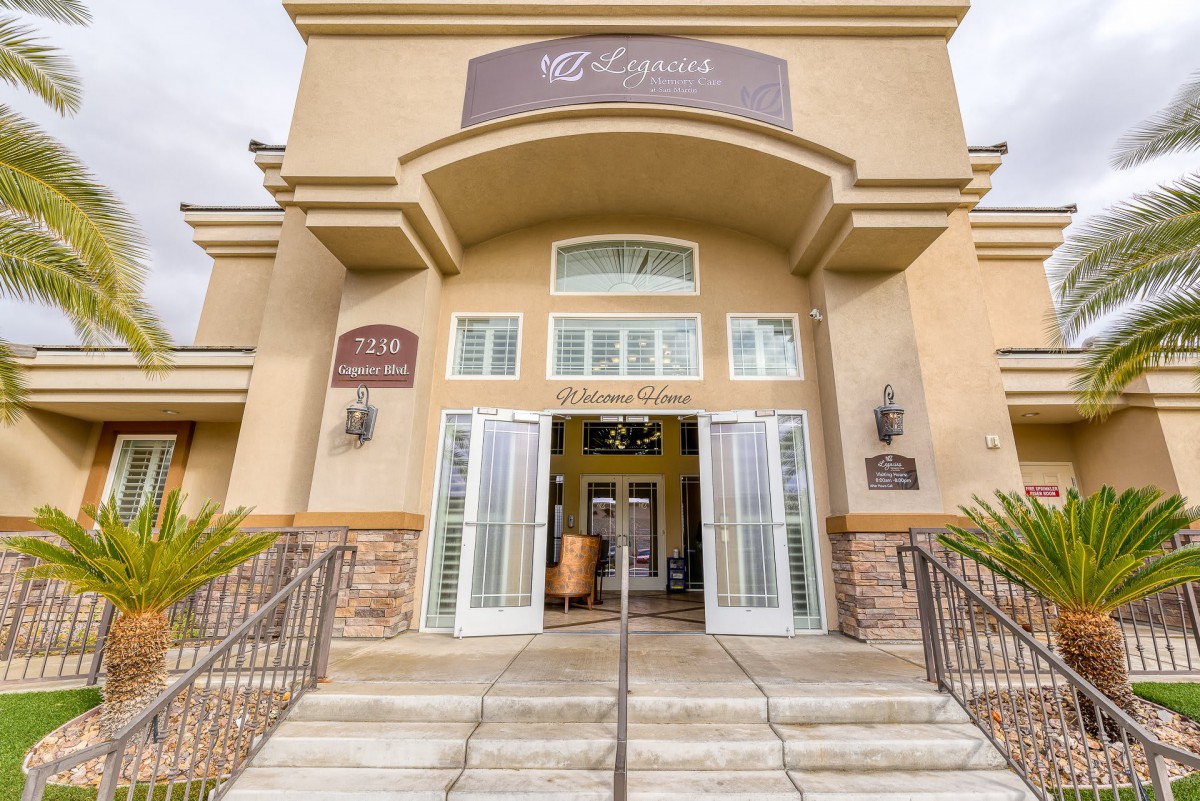 The entrance to a commercial building with wide stairs and large doors.
