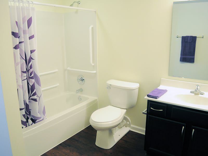 A neatly organized bathroom with a toilet, bathtub, and sink.