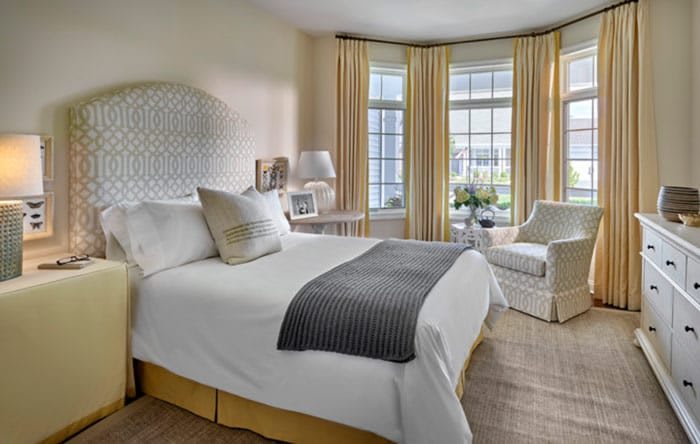 A cozy and elegantly designed bedroom with large windows and soft lighting.