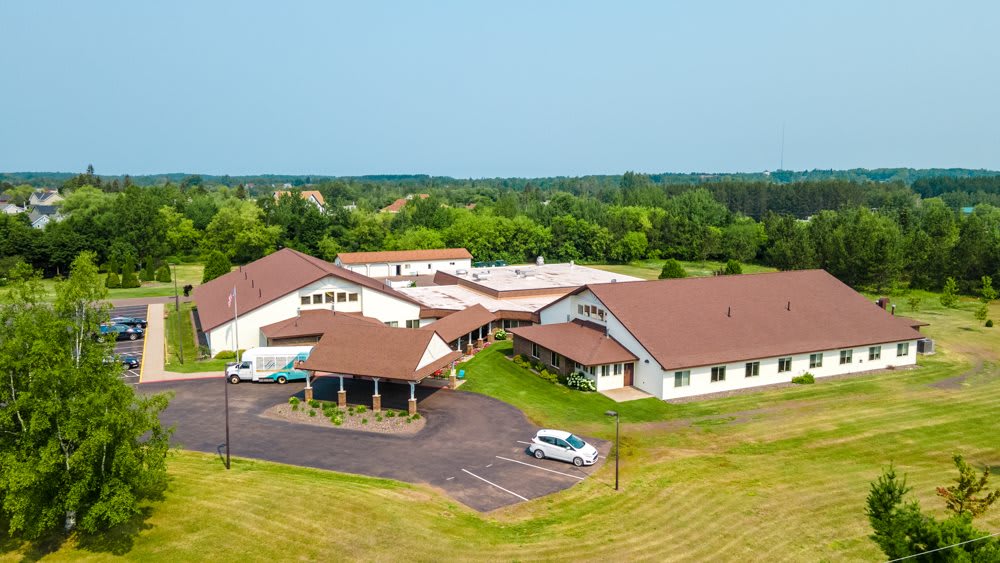 Aerial view of a large building complex in a rural area surrounded by greenery.