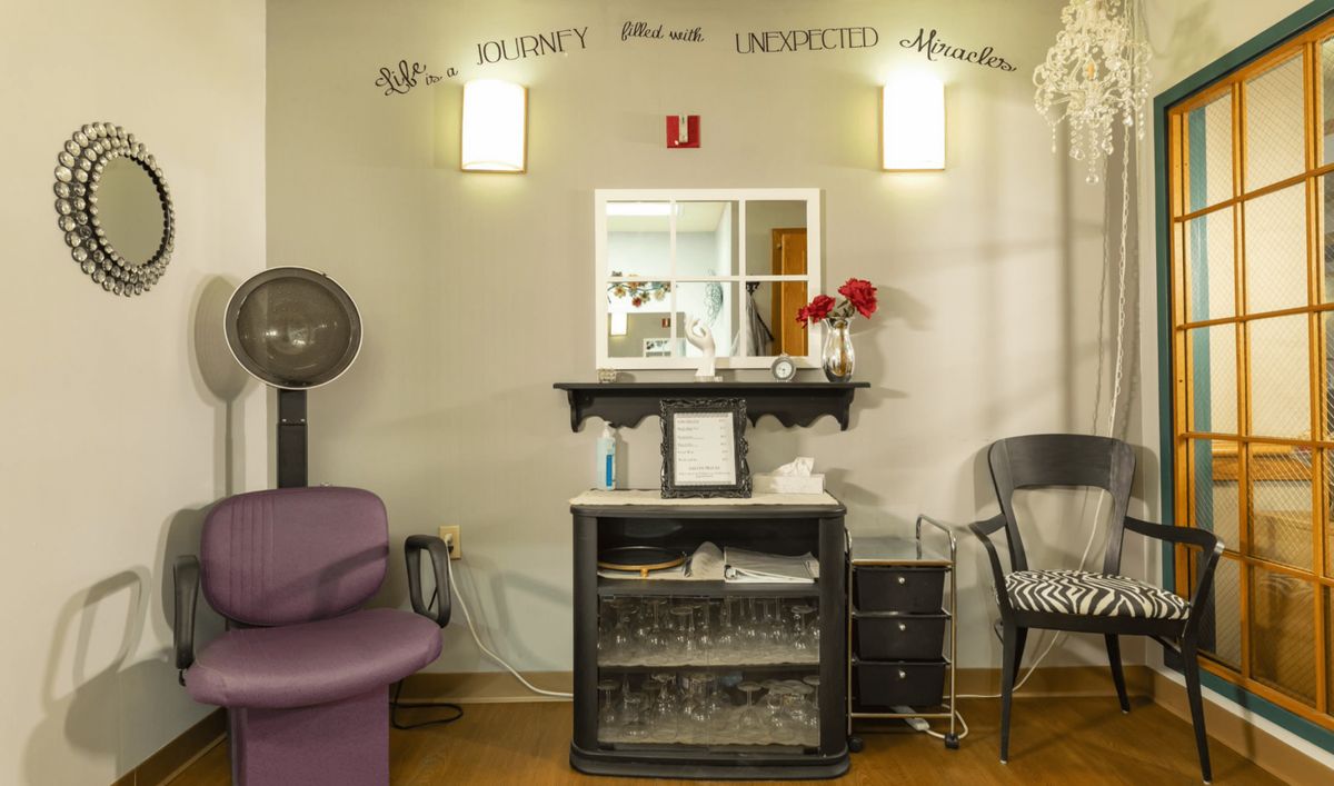 A cozy salon interior featuring a mirror, hair dryer, and decorative elements.