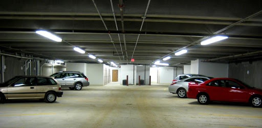 A spacious and well-lit parking garage featuring parked cars.
