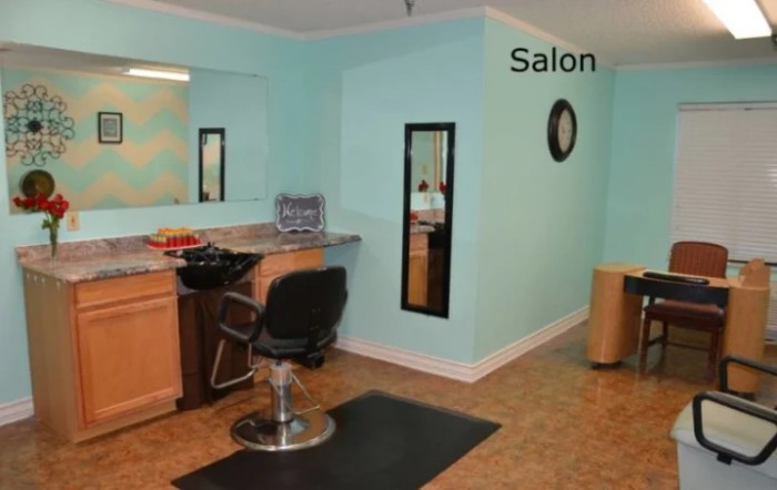 An interior view of a hair salon with a styling chair and mirror.