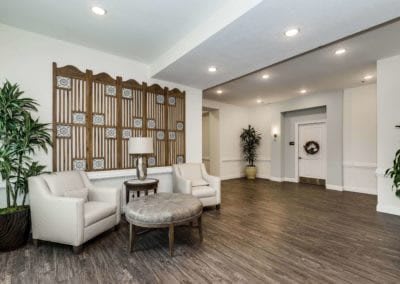 A cozy living room with elegant furniture and a decorative wall panel.