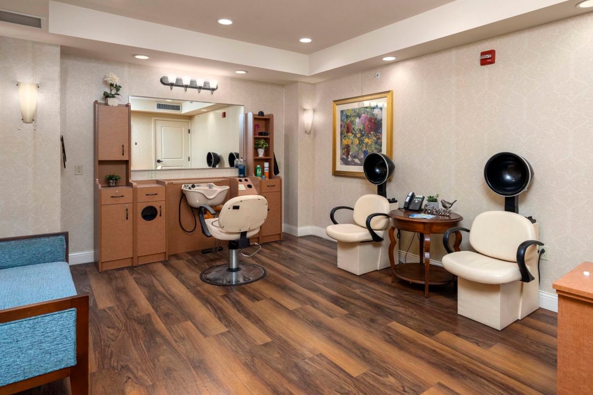 A stylish and well-equipped hair salon interior with comfortable seating and mirrors.