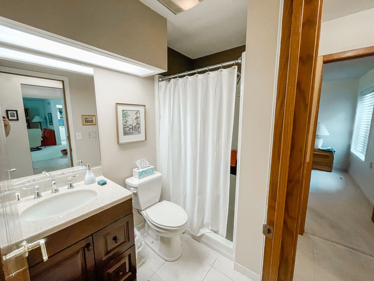 A clean and modern bathroom with a sink, toilet, and shower area.