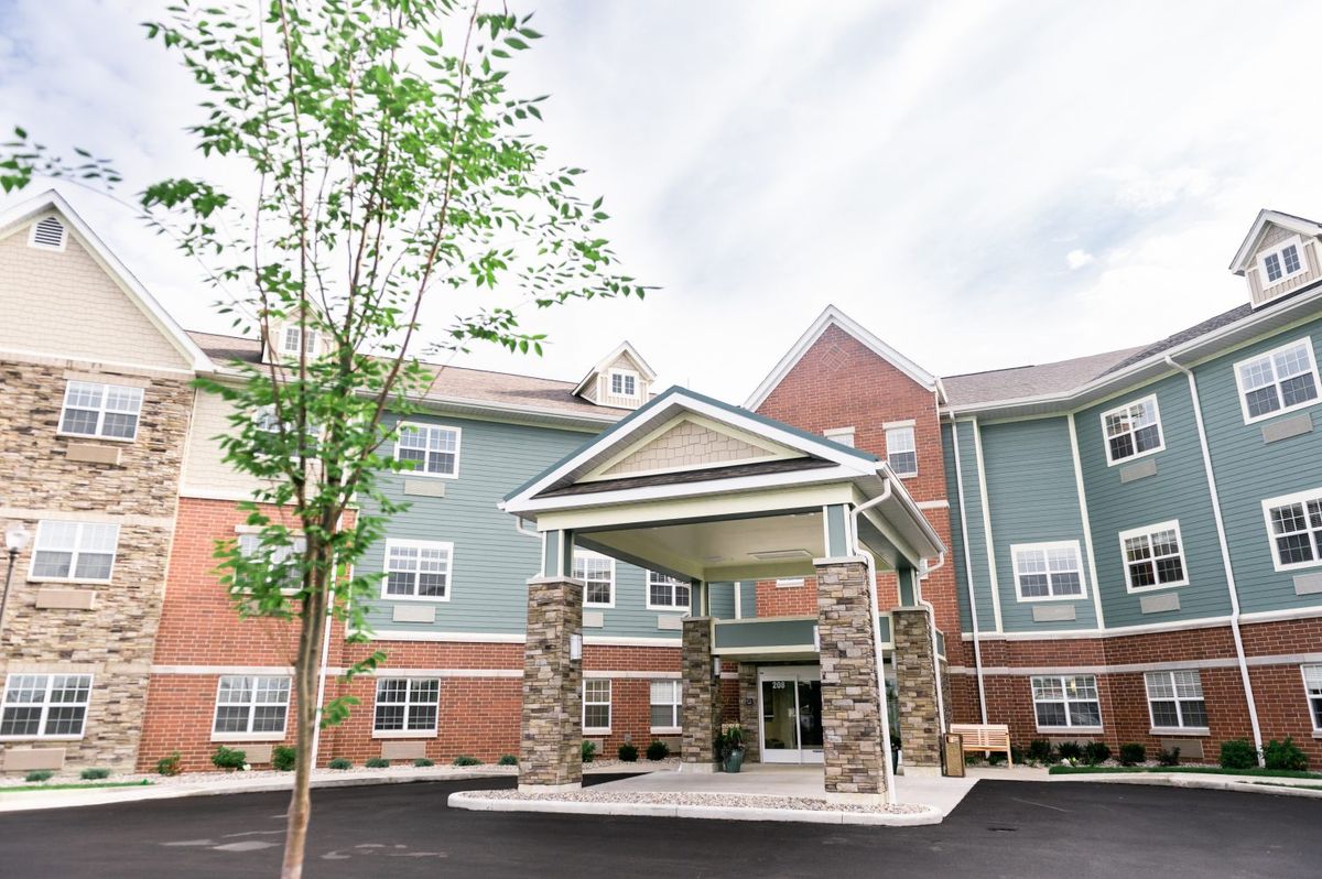 The exterior of a modern multi-story building with a prominent entrance and surrounding trees.