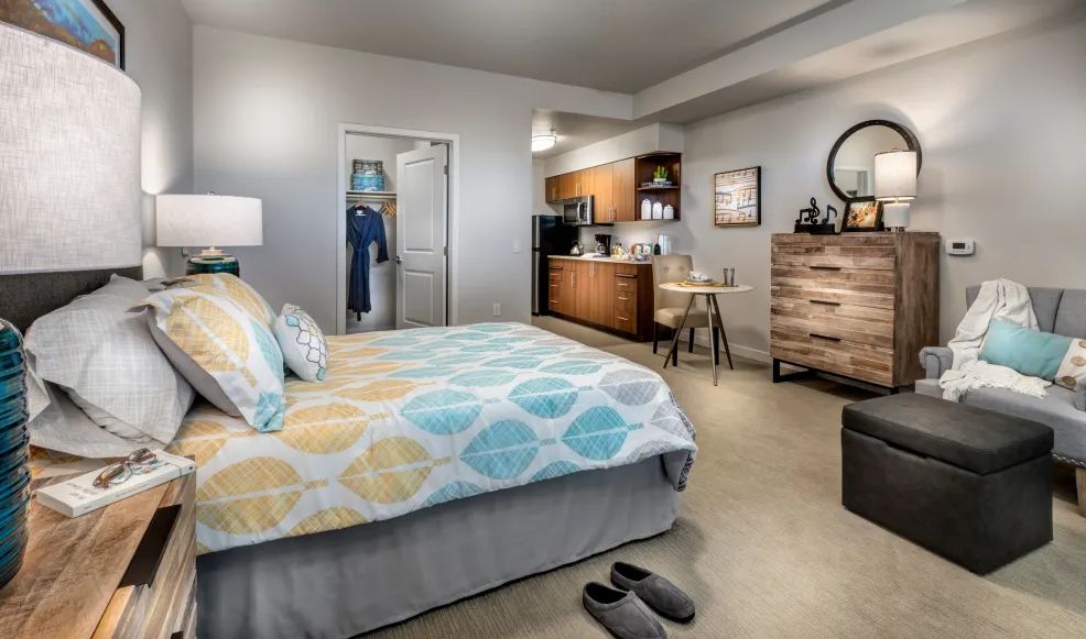 A cozy studio apartment with a comfortable bed, small kitchenette, and stylish decor.