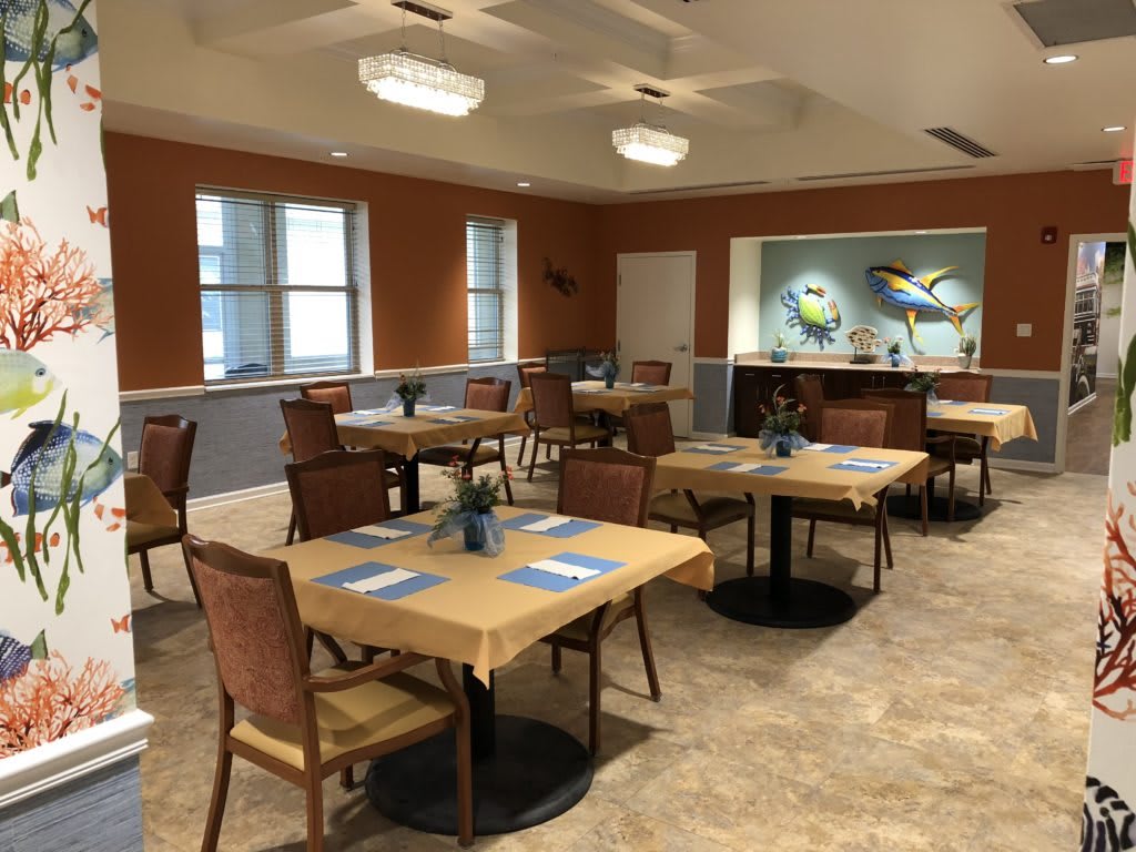An empty dining area with neatly arranged tables and chairs, featuring stylish decor and wall art.