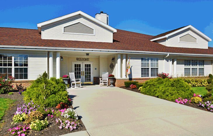 A well-maintained residential building entrance with a landscaped garden.