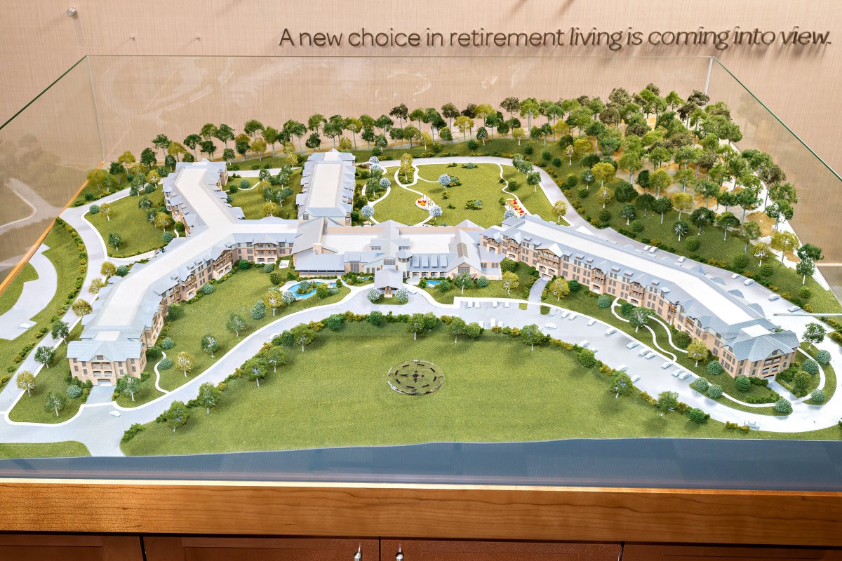 An architectural model showcasing a new retirement living community with landscaped grounds.