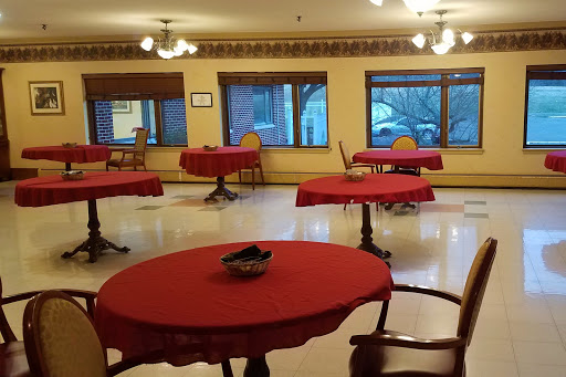 A dining area with red tablecloths and natural light from large windows.