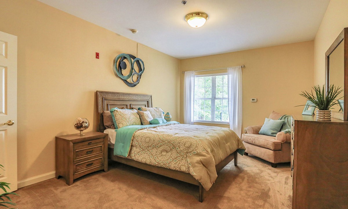 A cozy bedroom with soft lighting, featuring a large bed and warm decor.
