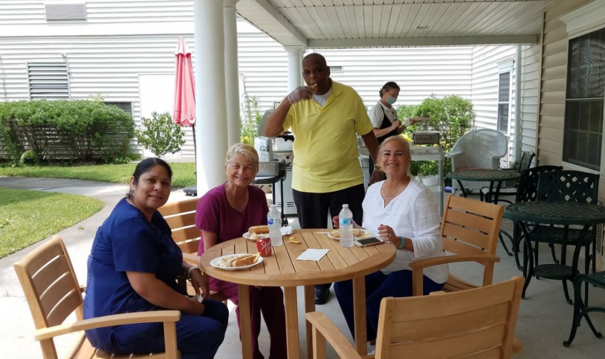 A group of people enjoy a casual outdoor gathering around a table.
