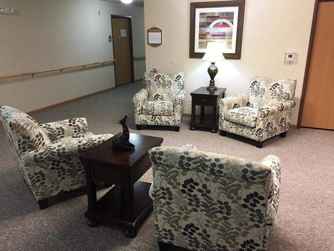 A cozy waiting area with patterned chairs and a small central table under soft lighting.