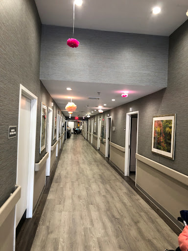 A long, well-lit hallway featuring multiple doors and decorative lighting.