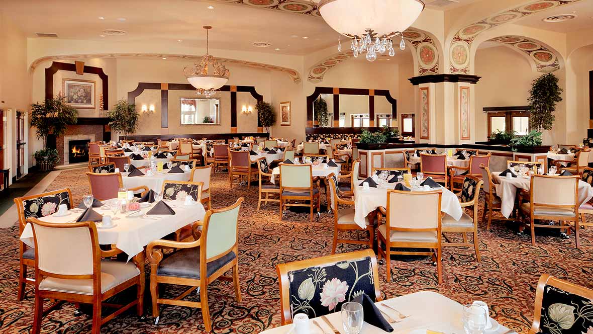 An elegant dining area with well-arranged tables and chandeliers.