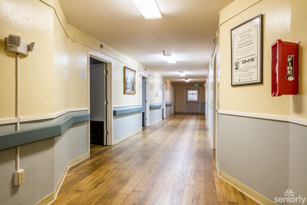 A well-lit hallway with wooden flooring and adorned walls.