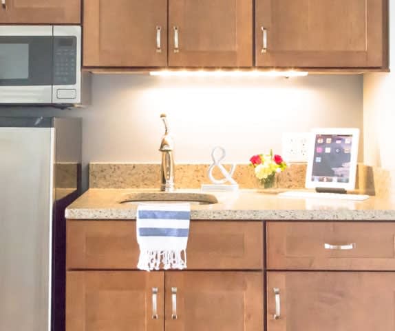 Modern kitchen with wooden cabinets, a countertop sink, and decorative items.