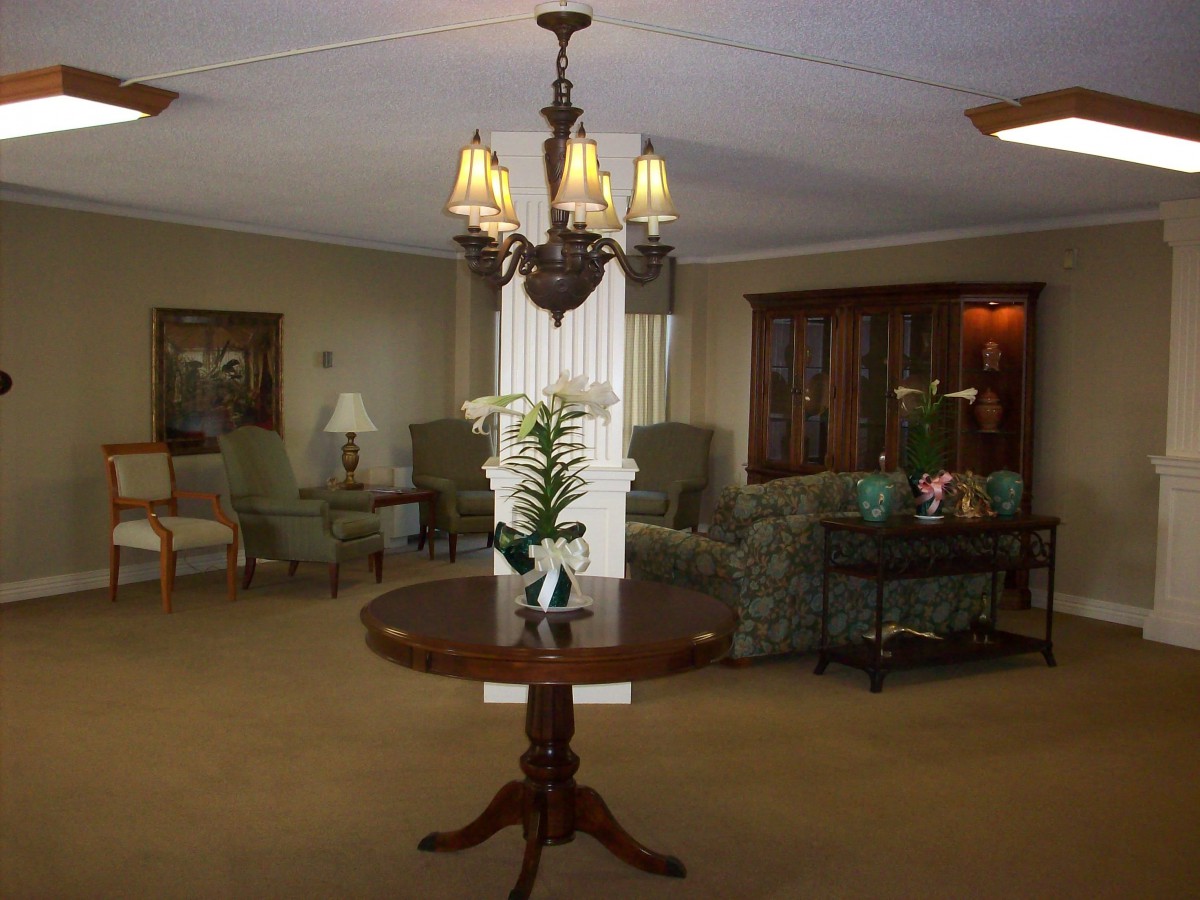 A cozy living room with elegant furniture and a central chandelier.