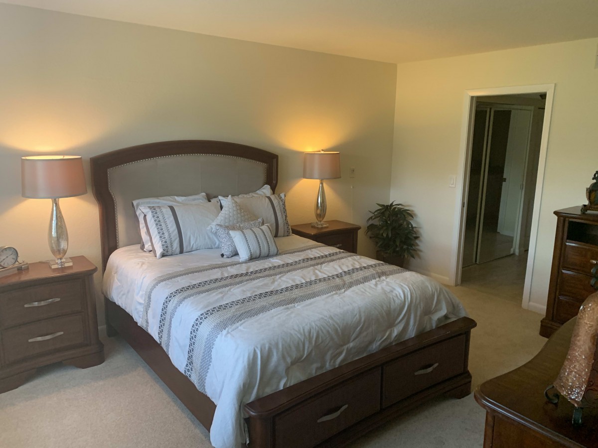 A cozy bedroom with a neatly made bed and warm lighting.