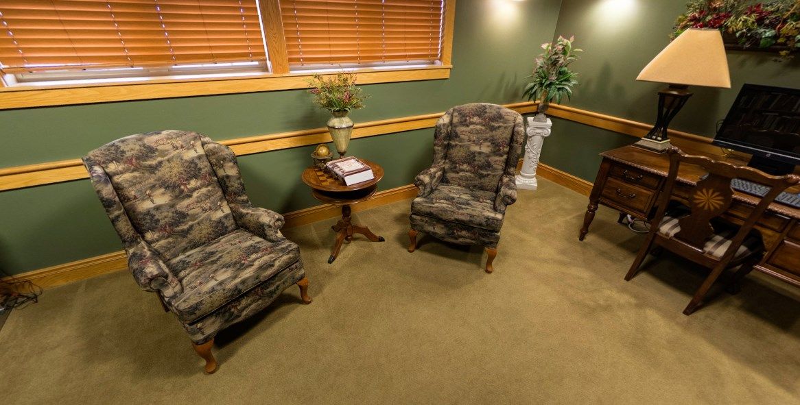 Cozy living room with camouflage-patterned chairs and green walls.