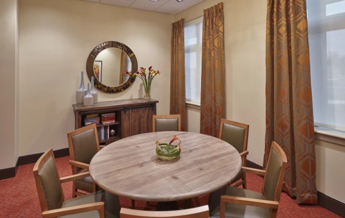 A well-decorated conference room with a round table and chairs.