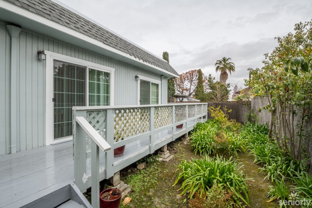 A residential backyard with a wooden deck and garden area.