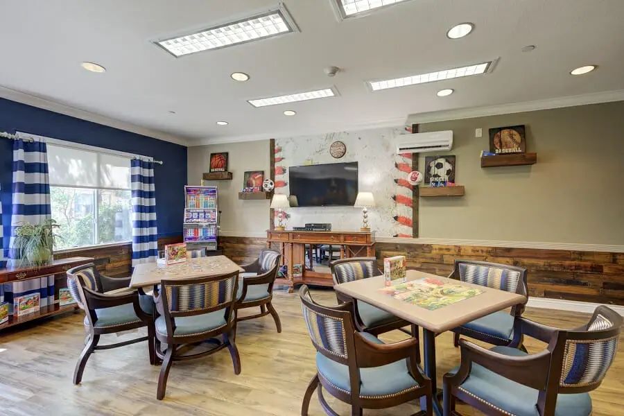 A cozy and well-decorated indoor social area with tables, chairs, and a television.
