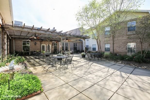 A sunny courtyard with outdoor seating and a pergola.