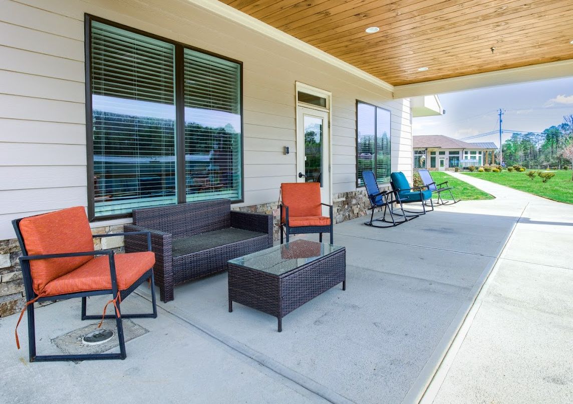 Modern patio area with seating and large windows.