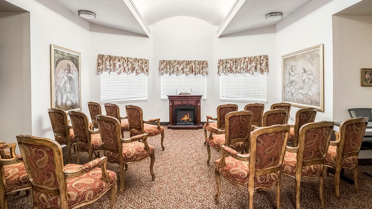 A small meeting room with ornate chairs and a fireplace.