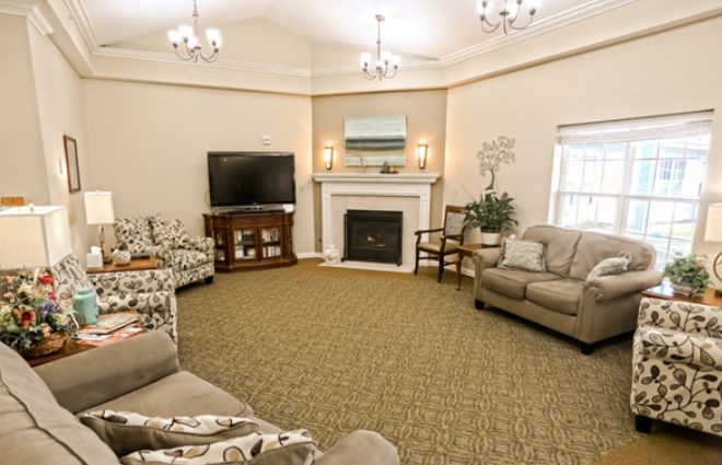 A cozy living room with sofas, a fireplace, and a television.