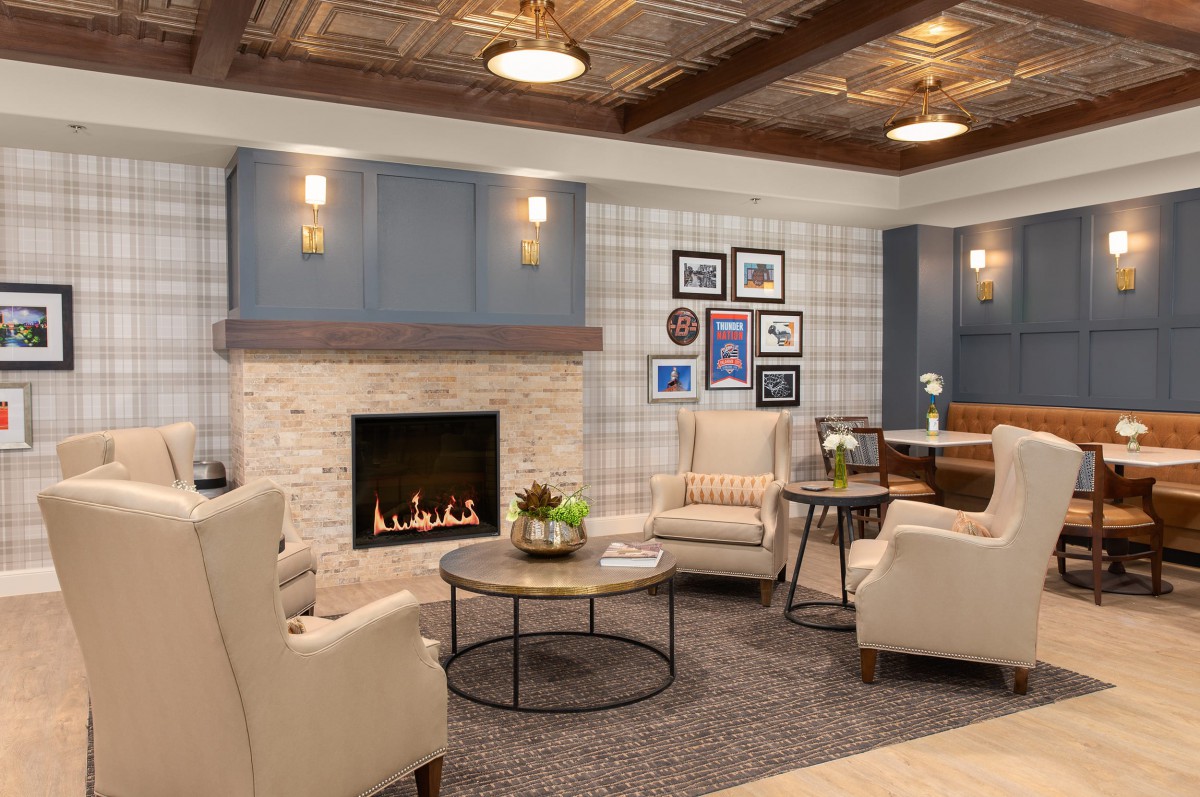 A cozy living room with modern decor, featuring a fireplace and comfortable armchairs.