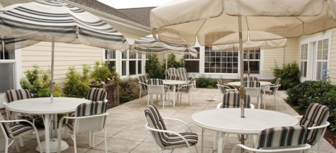 Charming patio area with striped cushioned chairs and umbrellas for shade.