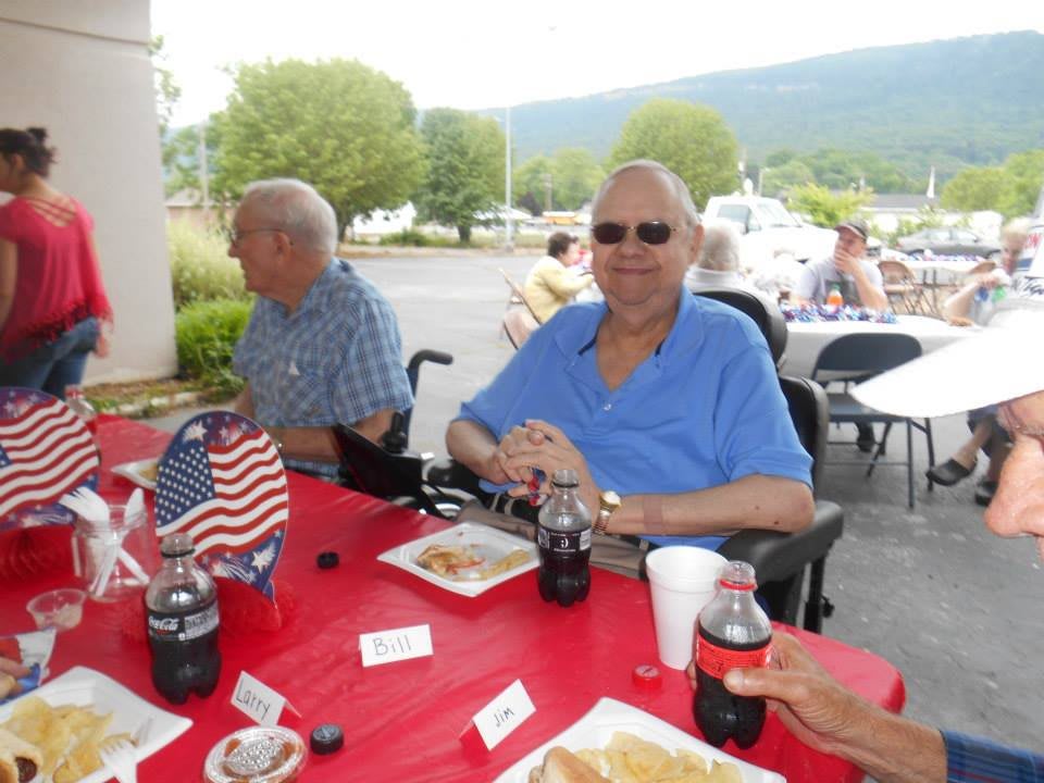 A group of people enjoying an outdoor gathering with food and drinks.