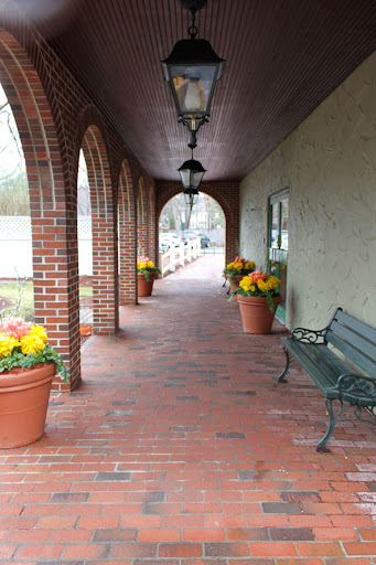 A serene corridor adorned with flower pots and elegant arches.