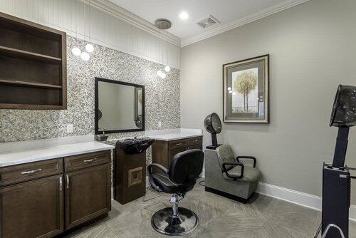 A stylish hair salon interior with a mirror and comfortable chairs.